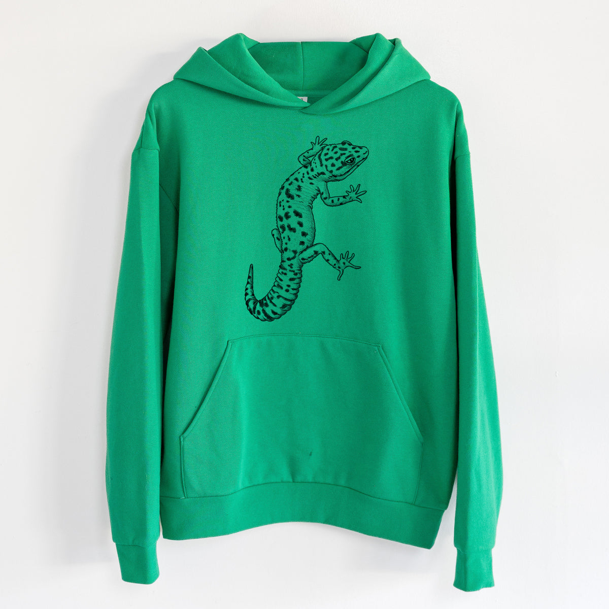 Eublepharis macularius - Leopard Gecko - Statement Midweight Hoodie in Kelly Green, hanging on a white wall, with a front kangaroo pocket and no drawcords.
