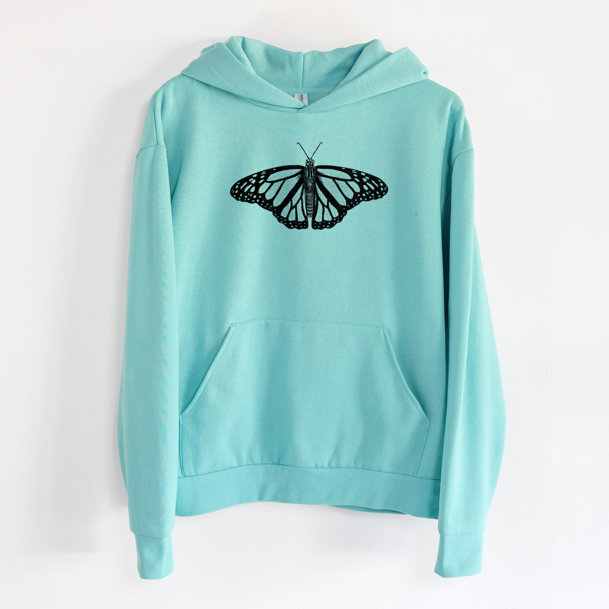 Danaus plexippus - Monarch Butterfly - Statement Midweight Hoodie in Seafoam, hanging on a white wall, with a front kangaroo pocket and no drawcords.