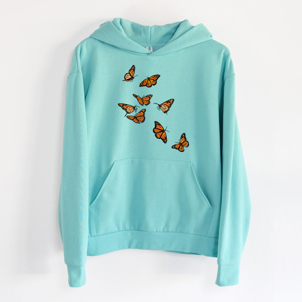 Monarch Migration - Statement Midweight Hoodie in Seafoam, hanging on a white wall, with a front kangaroo pocket and no drawcords.