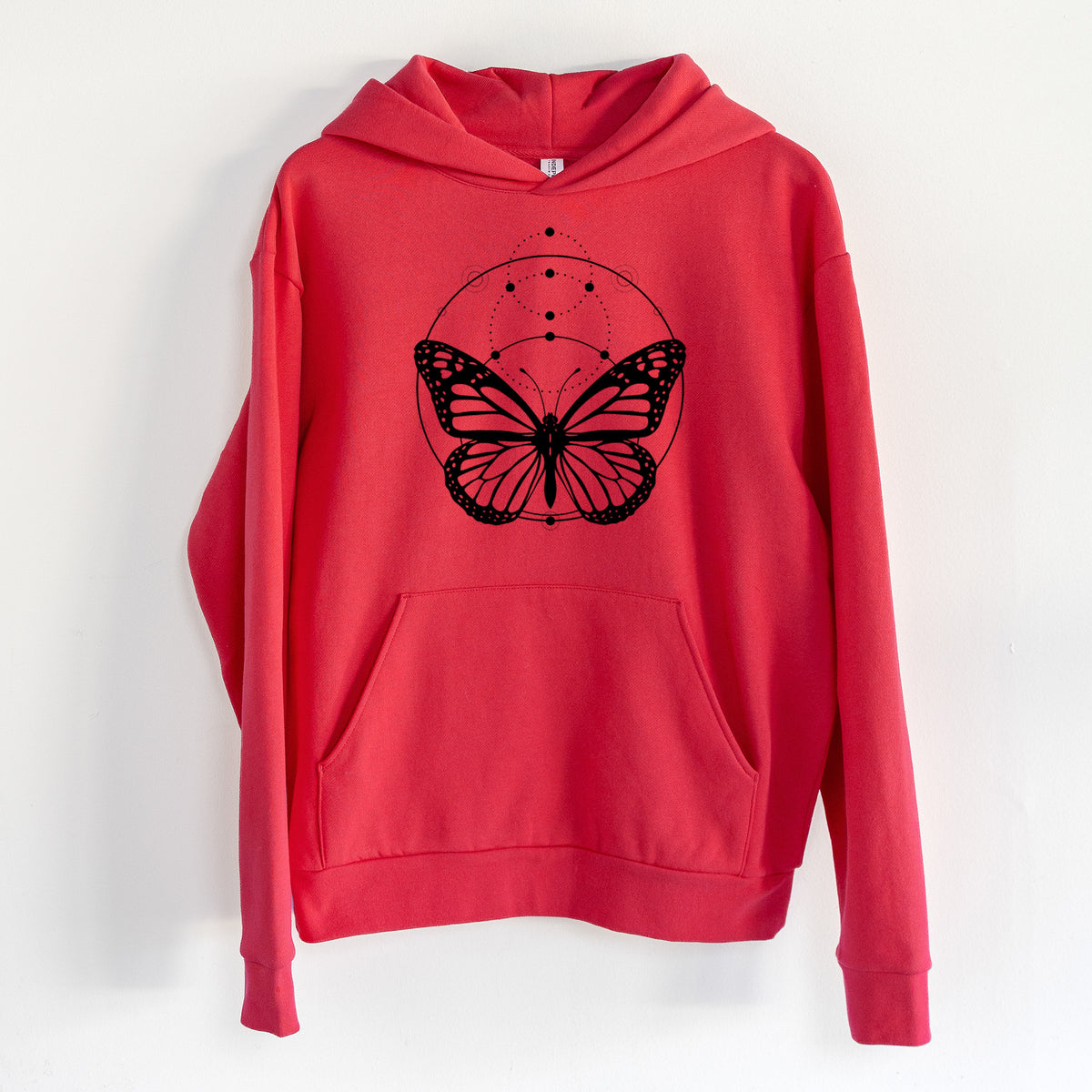 Monarch Symmetry - Statement Midweight Hoodie in Cherry Red, hanging on a white wall, with a front kangaroo pocket and no drawcords.