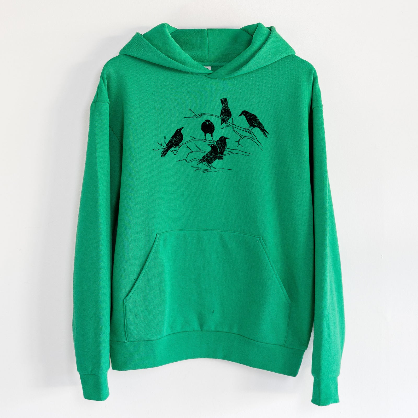 Murder of Crows - Statement Midweight Hoodie in Kelly Green, hanging on a white wall, with a front kangaroo pocket and no drawcords.