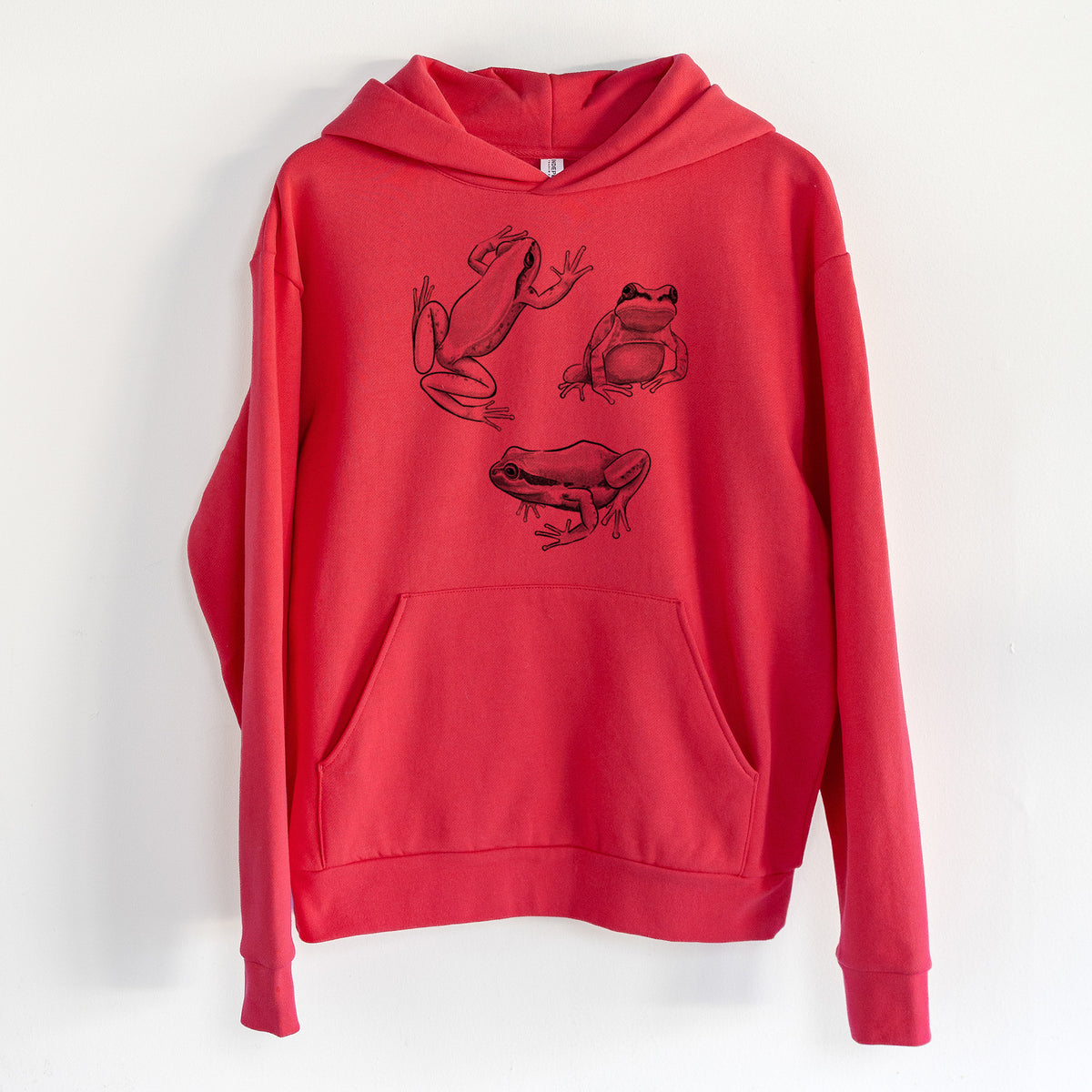 Pacific Tree Frogs - Pseudacris regilla - Statement Midweight Hoodie in Cherry Red, hanging on a white wall, with a front kangaroo pocket and no drawcords.