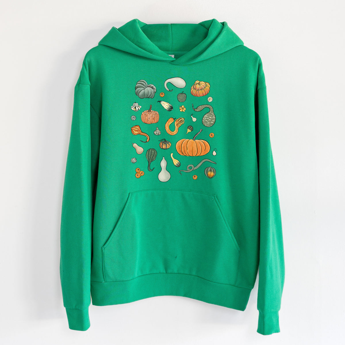 Pumpkin Patch Finds - Statement Midweight Hoodie in Kelly Green, hanging on a white wall, with a front kangaroo pocket and no drawcords.