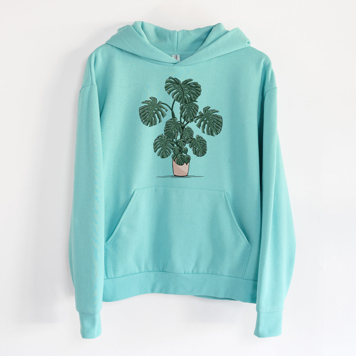 Potted Monstera Plant - Statement Midweight Hoodie in Seafoam, hanging on a white wall, with a front kangaroo pocket and no drawcords.