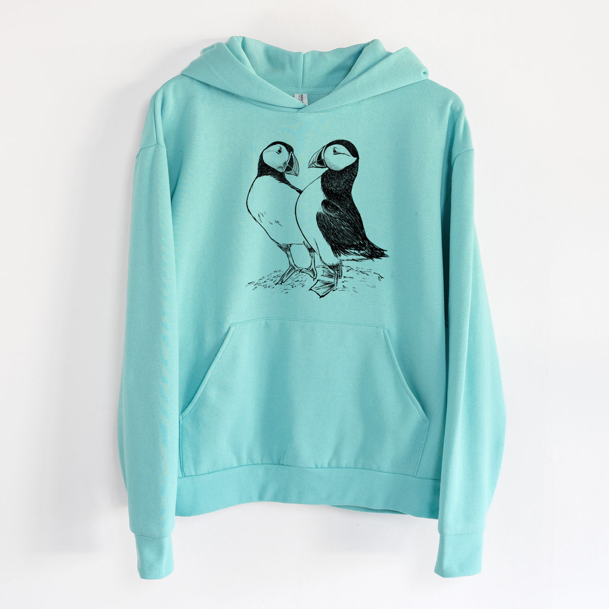 Atlantic Puffins Pair - Fratercula arctica - Statement Midweight Hoodie in Seafoam, hanging on a white wall, with a front kangaroo pocket and no drawcords.