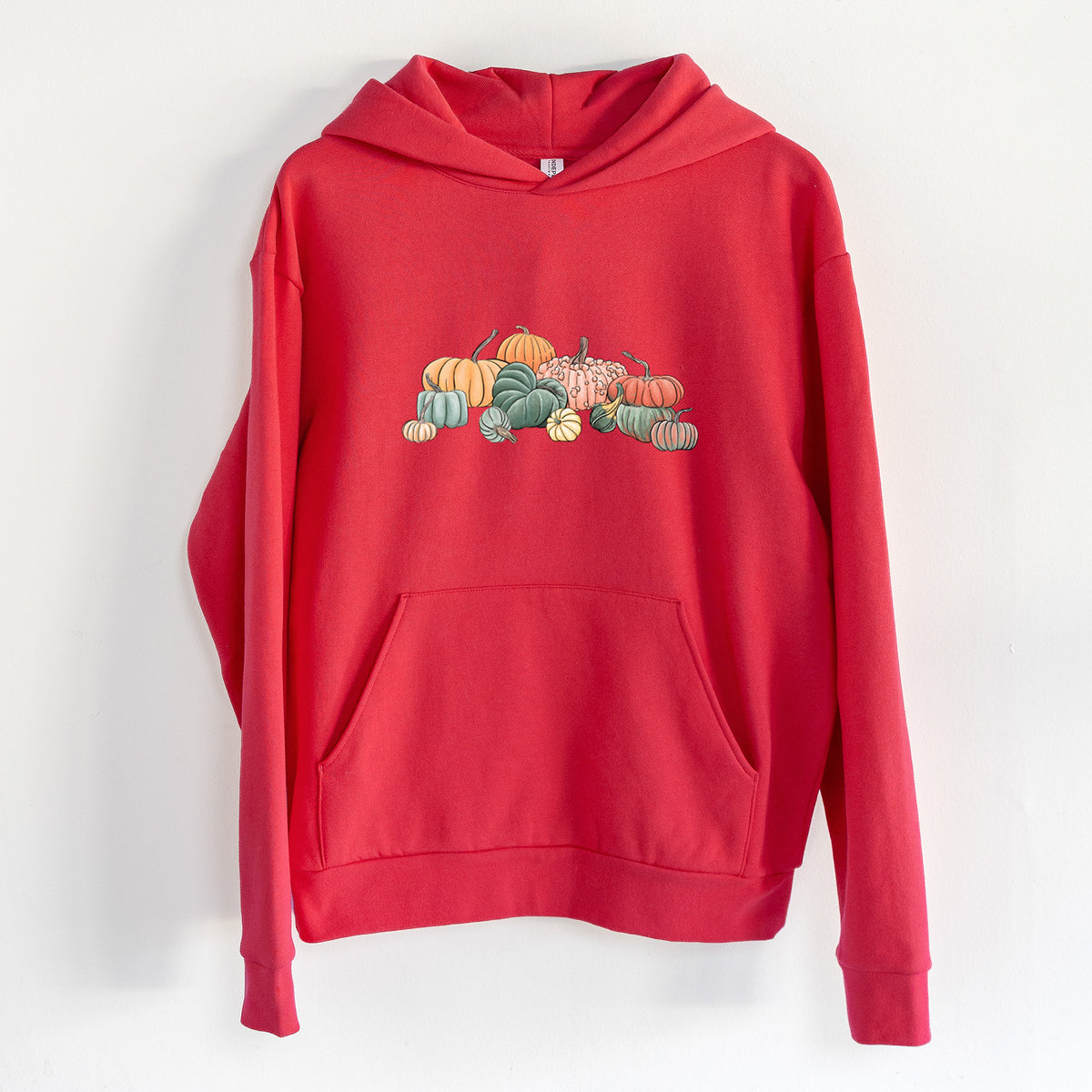Pumpkin Harvest - Statement Midweight Hoodie in Cherry Red, hanging on a white wall, with a front kangaroo pocket and no drawcords.