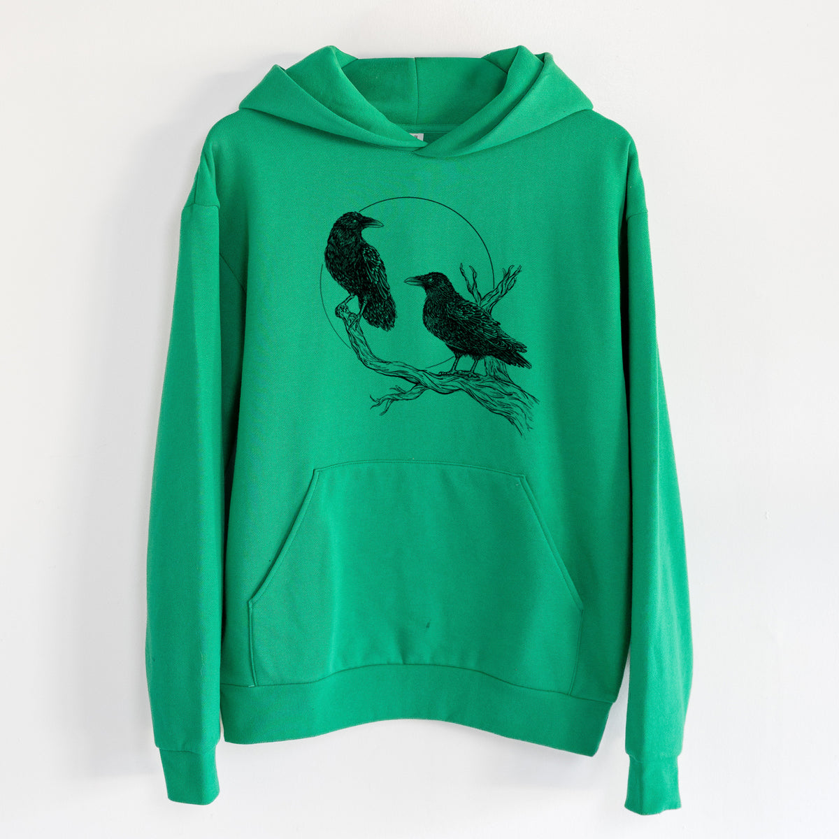 Midnight Ravens - Statement Midweight Hoodie in Kelly Green, hanging on a white wall, with a front kangaroo pocket and no drawcords.