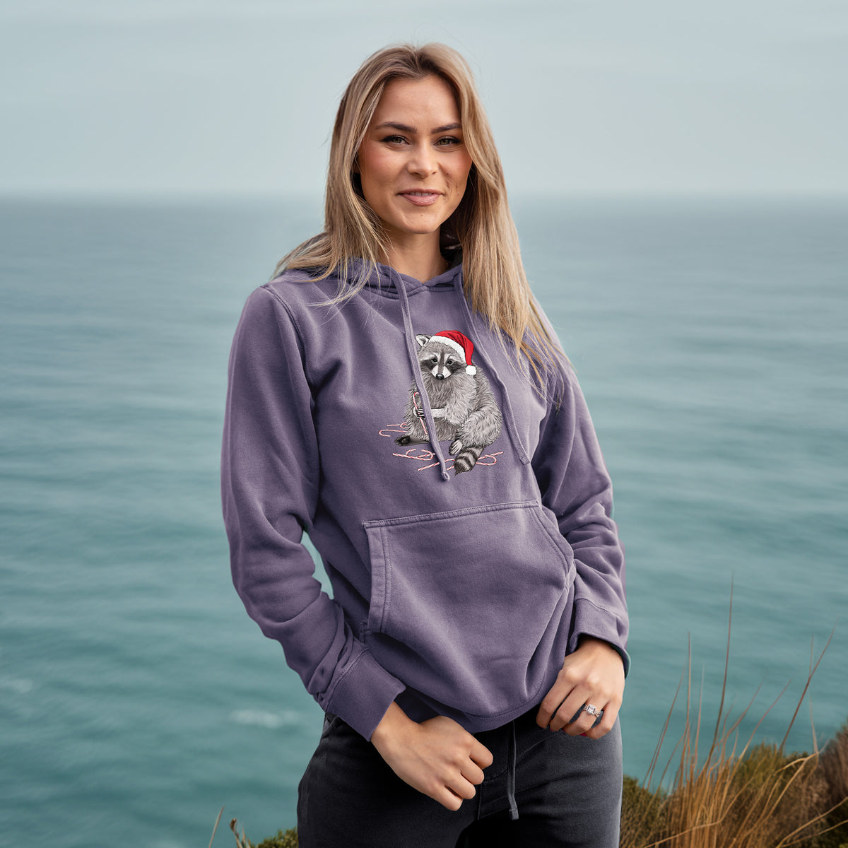 Santa Raccoon - Unisex Pigment Dyed Hoodie in Plum, worn by model