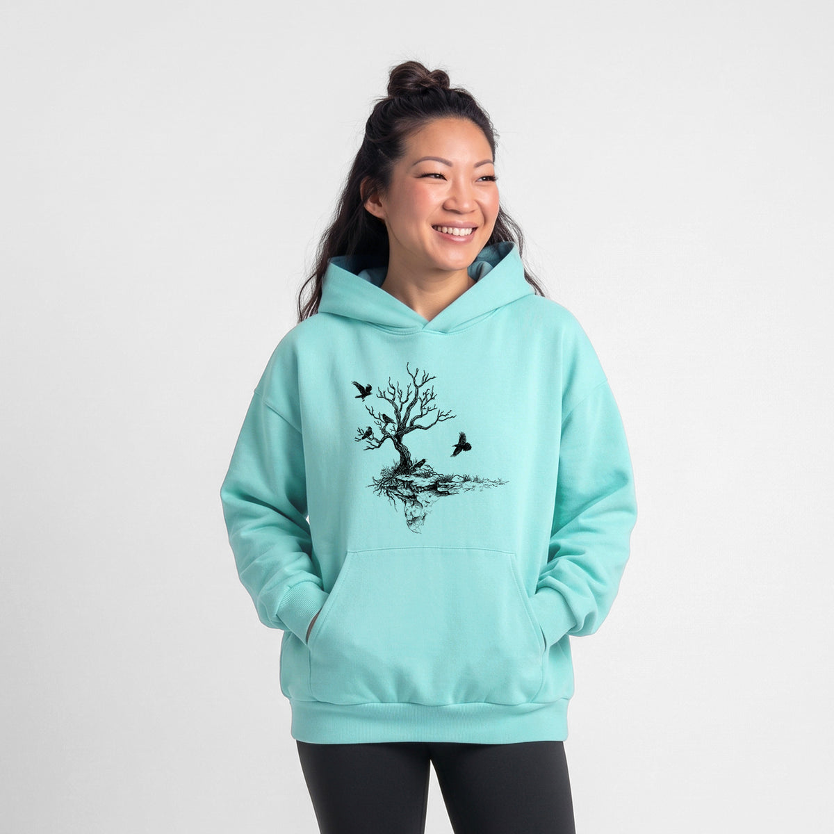 Female model wearing the Twisted Tree with Ravens - Statement Midweight Hoodie.