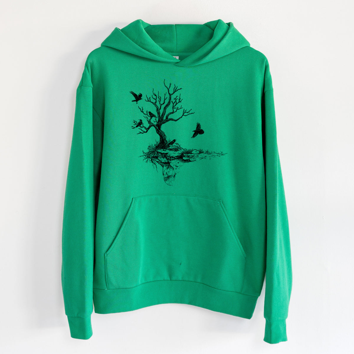 Twisted Tree with Ravens - Statement Midweight Hoodie in Kelly Green, hanging on a white wall, with a front kangaroo pocket and no drawcords.