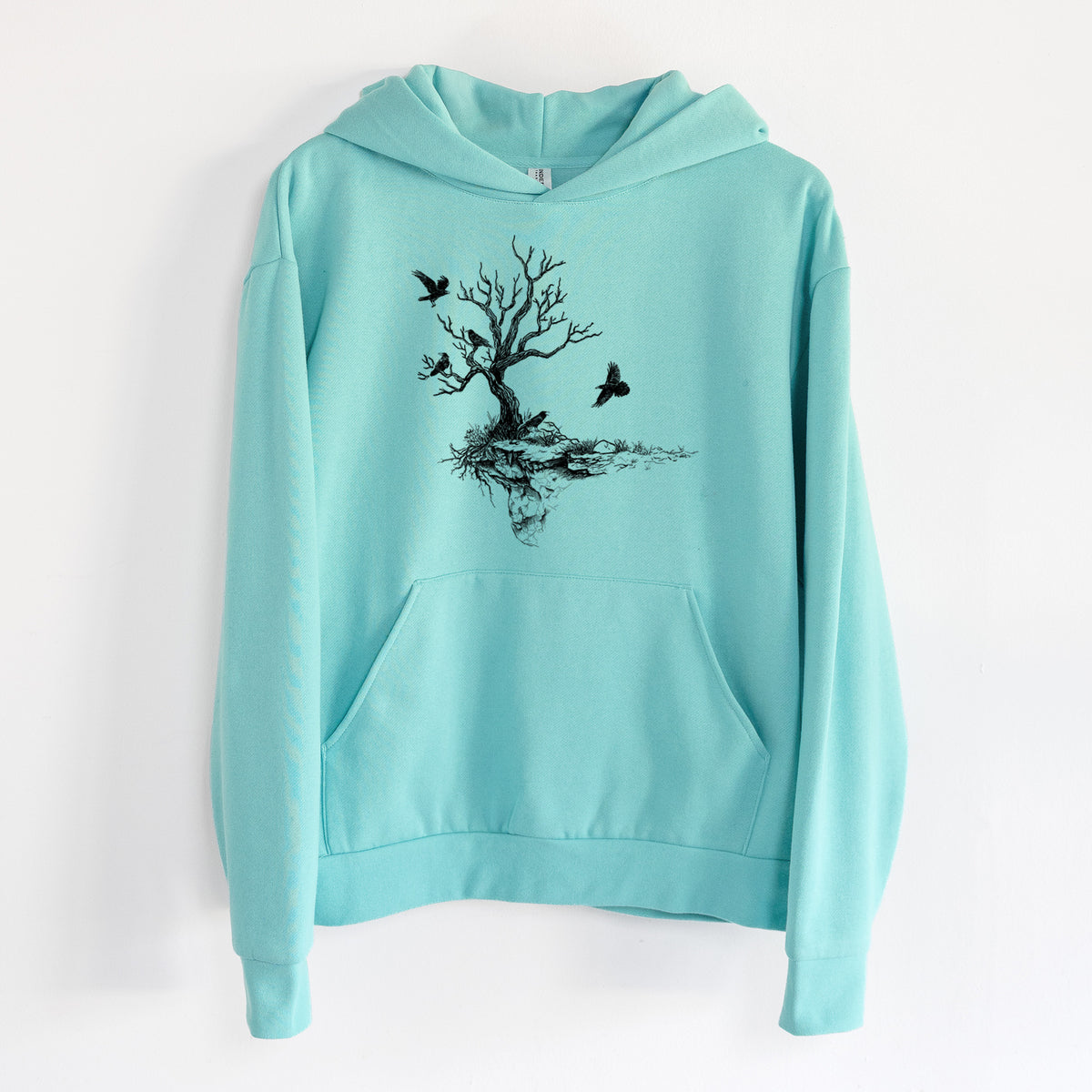 Twisted Tree with Ravens - Statement Midweight Hoodie in Seafoam, hanging on a white wall, with a front kangaroo pocket and no drawcords.