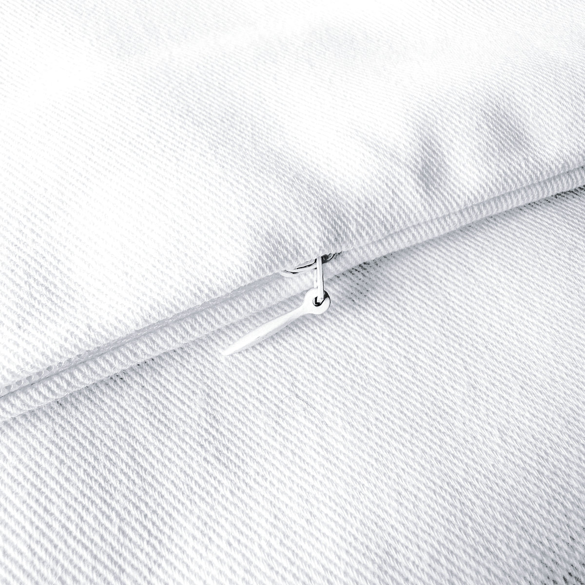 Close-up of a white fabric with a zipper, showing texture and stitching details.