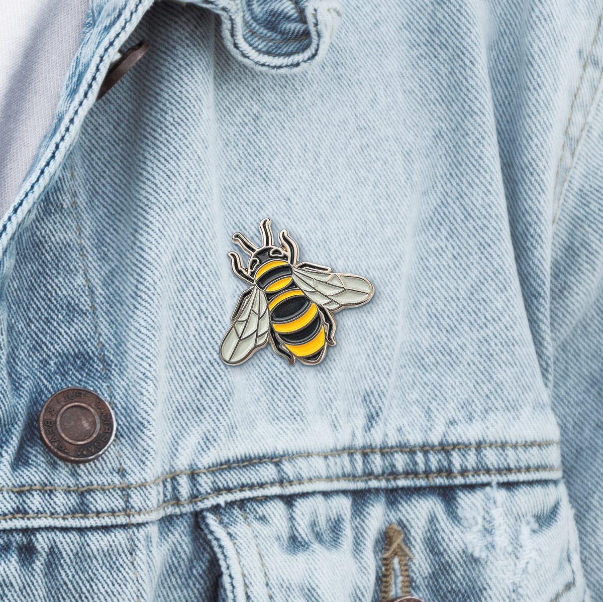 Honeybee enamel pin on a denim jacket
